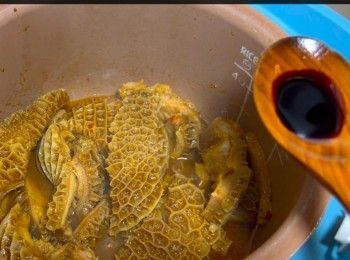 step13: 30分鐘後，我的「煲飯模式」結束，打開電飯煲，加入一茶匙老抽作調色、少許麻油增添香味。
最後可以打少許生粉芡，使醬汁變得較濃，能充分掛在每條金錢肚上。