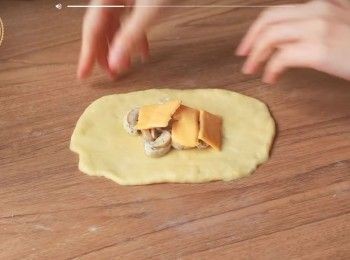 step3: 將<span class="group_2">餡料</span>材料拌勻，再把麵團捍成橢圓形後
放入適量蘑菇<span class="group_2">餡料</span>和芝士 再封口包好