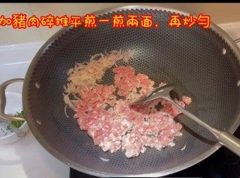 step7: 將炒香乾蔥推埋一邊，加豬肉碎推平，煎一煎兩面，再一齊炒勻