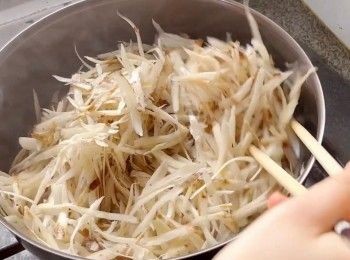 step5: 燒熱鍋、下少許油，倒入牛蒡絲，以中火將牛蒡絲炒香，然後加入甘筍絲炒勻。