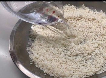 step2: 將已浸泡的糯米瀝乾水份，倒入一個平底的容器，加入油、鹽和清水拌勻。