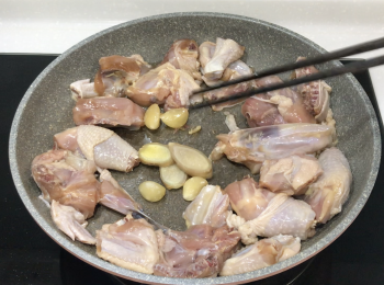 step3: 加油、薑片、蒜頭和雞，煎雞至兩面黃金色