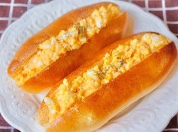 step5: 麵包稍稍放涼後用麵包刀在中間開口位切開，不要切到底， 然後放上<span class="group_2">碎蛋沙律</span>再灑上一點香草即完成