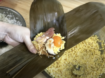 step2: 兩塊粽葉交叉放，中間摺出漏斗形，先放糯米、去皮綠豆，再放其他材料，之後再加去皮綠豆、糯米，左右各放一塊粽葉，向中間摺，上下摺(詳細步驟請參考Youtube影片）