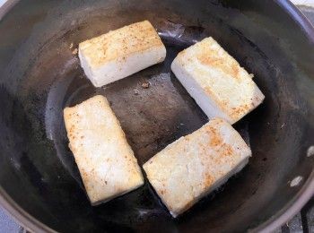 step6: 燒熱鍋、下少許油，待油熱好再放入豆腐塊，先以小火煎至一面金黃色，再反轉煎另一面至金黃色。
