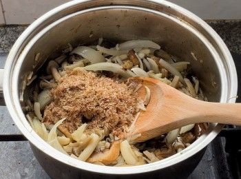 step6: 加入洋葱條、香菇乾、薑泥、木魚碎拌勻，再倒入調味料。