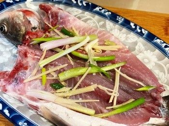 step5: 把薑絲和蔥白絲放魚身內，灑上少許鹽，把魚身反轉