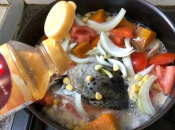 step4: 倒入蔬菜、熱水、味醂，煮沸後以中小火慢煮10分鐘至三文魚頭熟透。