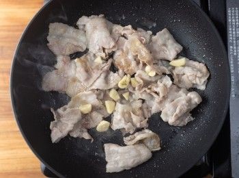 step2: 熱油鍋，將豬五花肉下鍋拌炒後加入大蒜炒香。