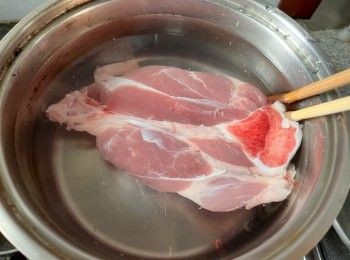 step3: 豬𦟌放進一鍋冷水中，開火煮沸先煮一下以煮出豬肉的多餘油脂和雜質，過冷河洗淨豬𦟌備用。