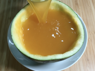 step5: 將碗裏的西瓜汁倒入西瓜汁和吉利丁的溶液，加入蜂蜜，攪拌，把混合物倒入西瓜盅，冷藏一夜