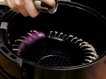 step3: 放入氣炸鍋噴油。
Spray oil over the eggplants.