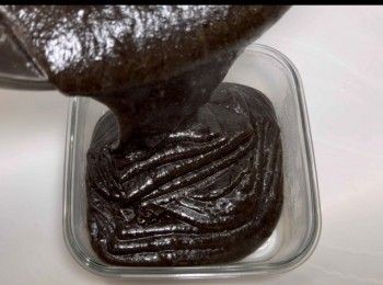 step10: 趁熱還帶有流動性時，將黑芝麻粉漿倒入已塗油的容器內。（我的容器尺寸是15cm x 15cm x 5cm)