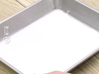 step5: 將適量椰漿倒進平底盤內，輕輕搖動使椰漿變成薄薄的一層，放置2分鐘待其凝固
Pour some coconut cream into the baking sheet, and shake it mildly to make li flat.Leave it for 2 minutes until it sets.