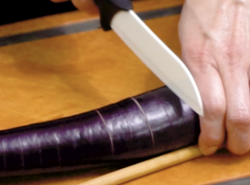 step1: 用筷子輔佐切茄子，避免切斷。將茄子切成厚片。
Place the eggplant between 2 chopsticks.Slice the potatoes into thin slices.