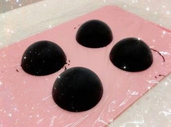 step2: <span class="group_1">朱古力流心餡</span>： 1. 將黑朱古力用熱水坐溶（亦可用微波爐加熱1.5分鐘成朱古力醬；朱古力加熱不可超過50°，否則會變質而失去光澤） 2. 鮮奶用微波爐加熱10秒至微暖，加入黑朱古力醬，拌勻至黑朱古力滑身（呈令面） 3. 再加入竹炭粉調成黑色 4. 將<span class="group_1">朱古力流心餡</span>分成一份份（20 g），加入矽膠半圓球形模具（4.5 cm），放進冰格冷凍3小時／1晚（較容易操作），備用