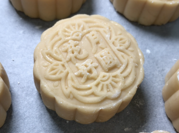 step5: 100克的月餅模沾粟粉，月餅團沾少許粟粉，搓揉至幼細狀，用月餅模用力壓2-3下，掃掉多餘粉末，噴水有助進烤箱後快速定型