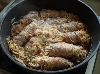 step5: 同鍋放入洋蔥、水、半包泡麵調味包以及其他調味煮滾。將豬肉捲放入湯中，蓋上鍋蓋小火煮1-2分鐘即可。