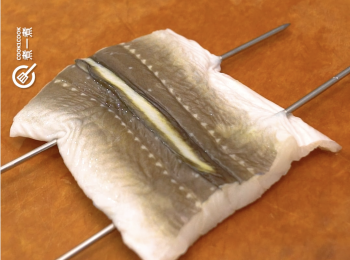 step2: 用竹或金屬簽穿過鰻魚身，以防熟後捲曲
Use bamboo or metal skewer to pass through the eel's body  to prevent them from curling up after cooked.