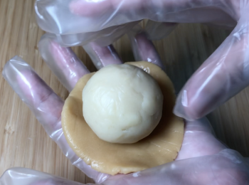 step4: 月餅皮麵團約重33克，用月餅皮麵團把蓮蓉餡和鹹蛋黃包起來，中間不留空氣
