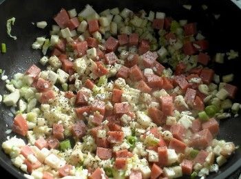 step2: 放入蒜末以及一半蔥花爆香。加入蛋白、火腿丁以及杏鮑菇拌炒均。