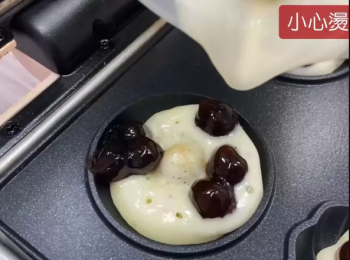step3: 先倒入淺淺的一層麵糊，約模型的1/3量，將珍珠8顆鋪在麵糊上，最後倒入麵糊與模型平行，蓋上上蓋烘烤約3分半鐘。