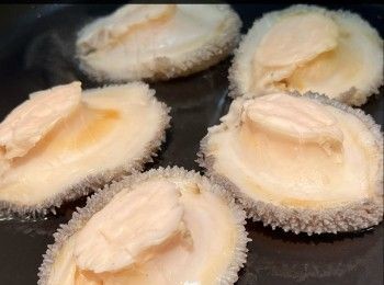 step5: 用Vermicular 22cm琺瑯鑄鐵鍋加入約九成水，放入鮑魚，鮑魚殼向下，小火，將水温維持70度慢煮1小時(我用温度計去量度水温，亦可用慢煮棒)，盛起；鮑魚水留用。