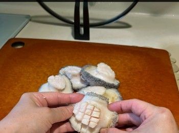 step4: 煲一鍋蝦眼水，放入鮑魚，約30秒後盛起，用牙刷在水喉下刷鮑魚，慢慢地刷洗，便可擦走那些黑色的污穢。