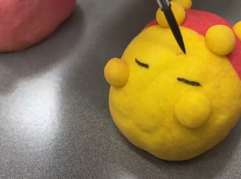 step6: 待冷卻後，取適量竹炭粉加入適量的水，調成黑色液體，再用畫筆於造型鳳梨酥上畫上其表情即可。