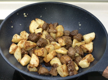 step5: 用油中火爆香蒜蓉，轉小火加薯仔，再加鹽，加牛柳粒後關火，馬上加黑胡椒、蜜糖、白芝麻，翻炒，完成