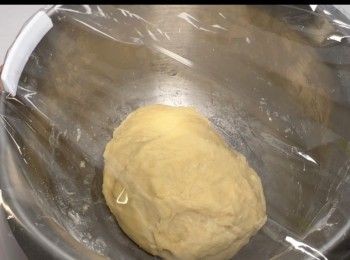 step9: 雙手沾上少許麵粉，將麵團搓揉1至2分鐘，然後將已蓋保鮮紙的麵團放到溫暖的環境（例如可以放到密封的櫃內或爐內，座在溫暖的熱水中，可提升發酵效果）進行第一次發酵，需時約30分鐘，麵團會發至1.5至兩倍大。


當完成第一次發酵之後，重複以上動作，取出麵團搓揉1至2分鐘，讓麵團進行第二次發酵。

進行第二次發酵，需時約30分鐘，麵團會再次發至1.5至兩倍大。