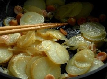 step4: 放入洋蔥炒軟，加入德式香腸炒出香氣，放入馬鈴薯片拌炒均勻。