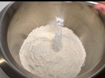 step6: 取出一個大容器，加入340克的中筋麵粉及1/3茶匙的梳打粉，輕輕混和。