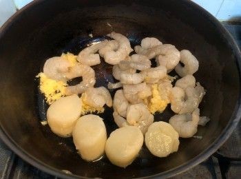 step5: 燒熱鍋、下少許油，待油加熱好後便加入大蒜碎炒香，之後加入帶子和蝦仁煎香，然後灑入白酒並繼續煎至兩邊呈金黃色，取出備用。