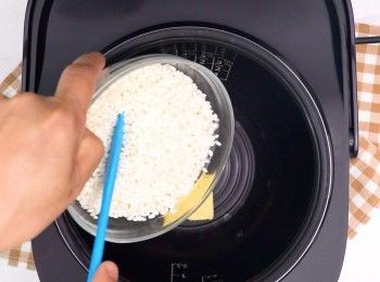step3: 米洗乾淨後，連同牛油放入電飯煲內，按快煮鍵先煮5分鐘
Rinse and drain dry rice. Put inside a rice cooker with butter and cook for 5 minutes.