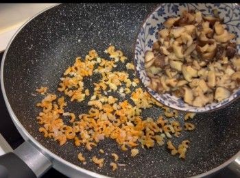 step4: 於鑊中加入適量的油，開中火，依次序爆香乾蔥頭、蒜蓉、蝦米和冬菇，爆炒至出香味，盛起備用。