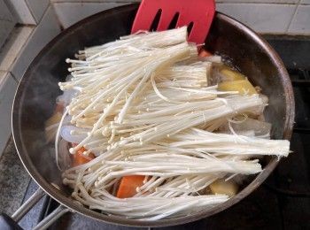 step5: 開火煮沸後加入金針菇、芋絲，拌勻、蓋上蓋子後以中火燉煮10分鐘。放入肥牛肉片回鍋，煮至牛肉熟透即可。