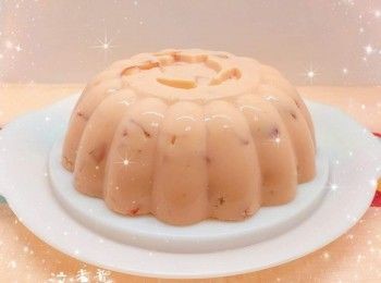 step7: 將剩餘的布丁水加入士多啤梨粒，拌勻後，慢慢及輕力的倒在半凝固的布丁上，放進雪櫃冷藏至凝固，脫模（可用牙籤沿模具邊緣畫一圈，然後將模具浸泡熱水約15秒／將模具倒轉，用熱毛巾包圍模具外圍約30秒／用熱水沖一下膜具，令布丁外圍軟化，較容易將布丁脫模），即可