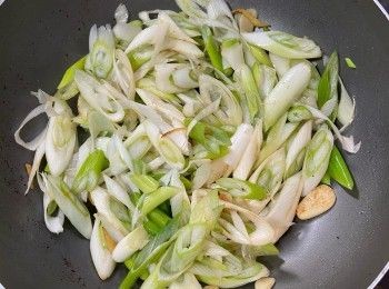 step3: 於同一鑊中熱油，爆香蒜片及薑絲，倒入京蔥以中火炒至軟身，加鹽炒勻。