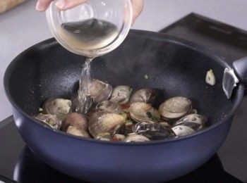 step2: 燒熱油，爆蒜頭、辣椒和芫荽梗，加入沙白爆炒，加入白酒。蓋上，焗至沙白打開。