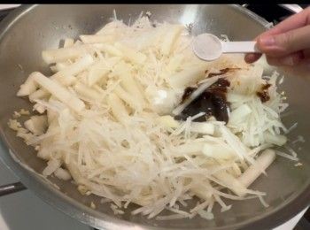 step9: 再起油鑊，爆香蒜蓉，以中火炒粗蘿蔔條約2分鐘，之後加入蘿蔔絲，多炒1分鐘。之後再落<span class="group_1">調味料</span>，包括糖、鹽、蠔油和胡椒粉。