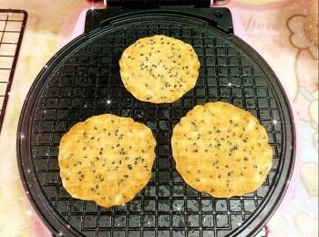 step6: 加入1小匙（約5-10 ml）粉漿於模具中（1小匙1塊；1次可做3塊），蓋上蓋子（夾緊，壓平粉漿），焗約2.5-3分鐘（至表面金黃），放涼