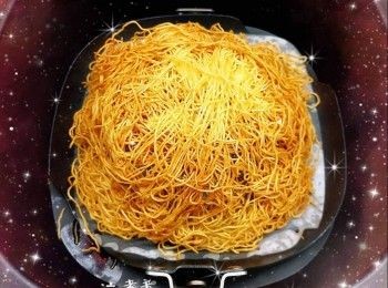 step3: 先將不銹鋼筲箕反轉放在煎盤上，然後將適量的蛋麵平均舖在筲箕上