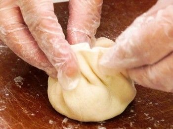 step8: 拿起邊轉邊摺，包成小籠包狀，再輕力壓扁
Shape the dough like a Xiao Lung Bao then press.