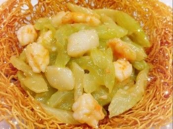 step7: 西芹洗淨，瀝水，先切去頭尾，然後用削皮刀削去了西芹表面的粗纖維，再斜切成粗條；將西芹加入煲滾熱水中，煲約1分鐘，瀝水，備用