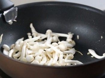 step4: 燒熱米糠油，加入蒜頭，再加入白玉菇，炒至均勻。