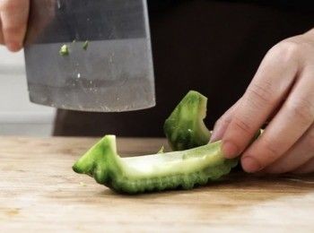 step1: 把苦瓜切半，去籽後切件。
Cut the bitter melon in half, discard the seeds and slice.