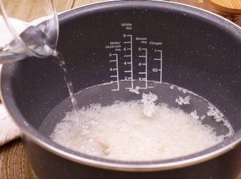 step2: 白米洗淨後瀝水，加入電飯煲內，按指示加水
關上蓋，選擇煲仔飯模式開始烹煮