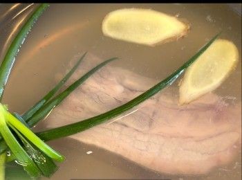 step1: 先把五花腩去毛清洗一下後，用薑、蔥和紹興酒汆水五分鐘，用冷水沖去肉上剩下的雜質，冰鎮備用。Clean and remove hair from pork belly skin. Add water, ginger, scallion and shaoxing wine to blanch the pork for 5 minutes. After blanching, clean the pork under running water then cool it in ice water.