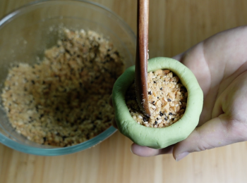 step4: 拿一份麵團，滾圓，母指沾油，挖空中間，放入適量餡料，收口滾圓